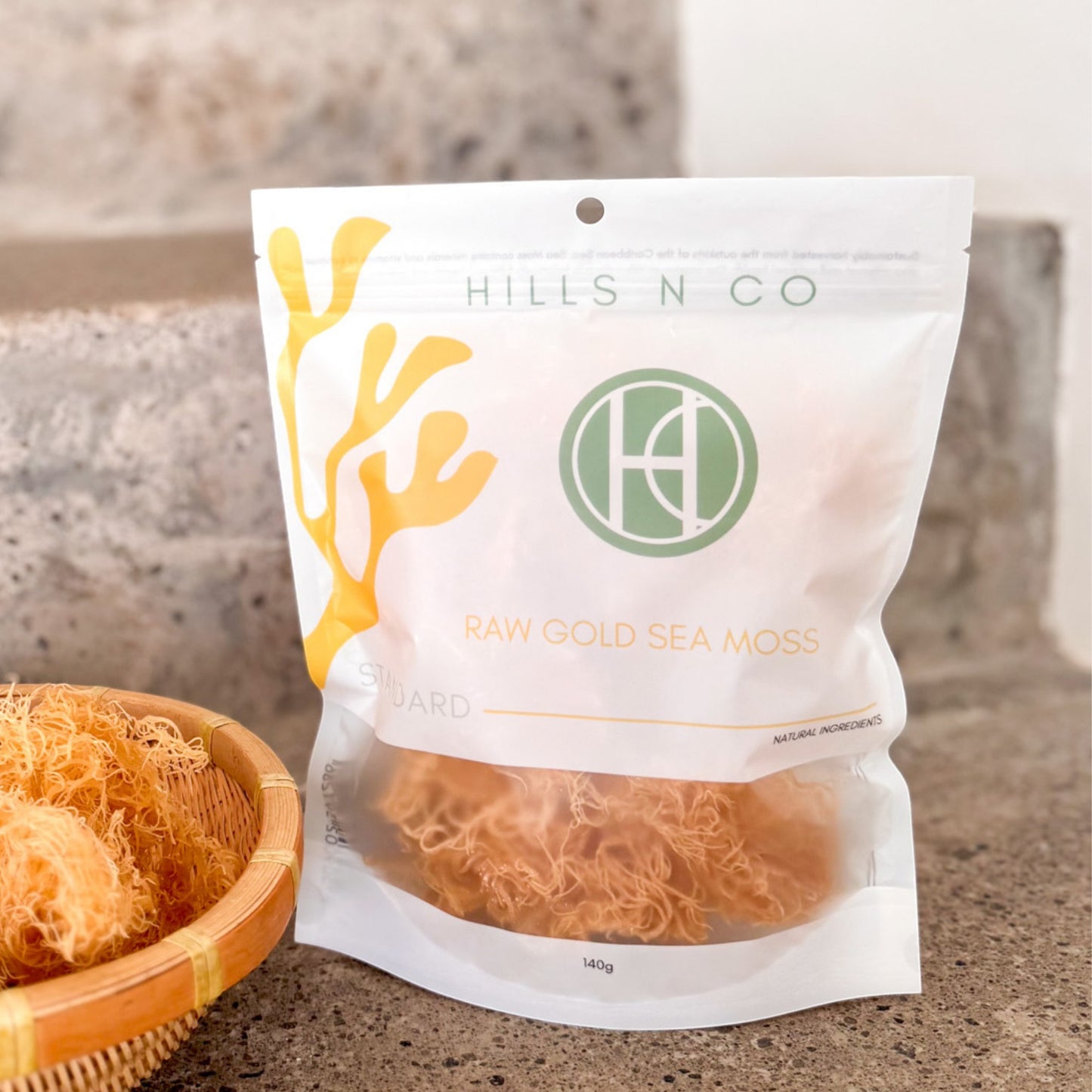 Hills N Co Raw Gold Sea Moss pouch with natural ingredients, 140g. Also shows a basket of dried sea moss.