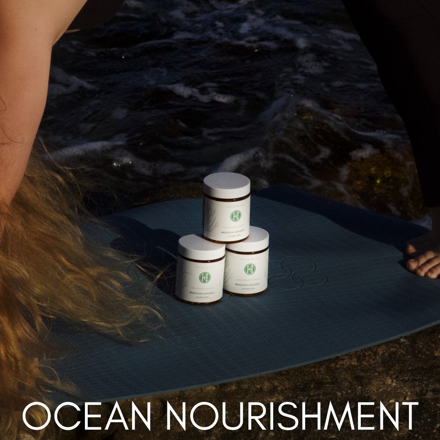 Hills N Co Sea Moss Capsules, 120 count, on a yoga mat by the ocean.